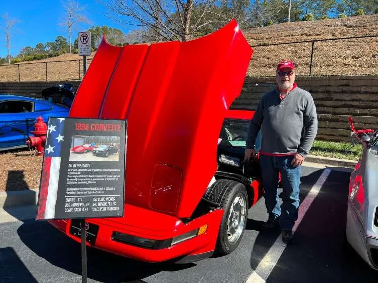 Fourth-generation red Corvette coupe with hood up.
