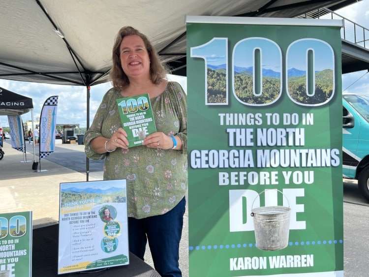 An author is holding up their book.