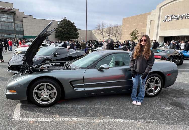 A man is standing beside a 2003 C5 Corvette coue