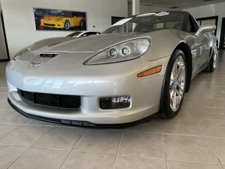 Silver 2007 Chevrolet Corvette Z06, low angle front driver's side view, chrome Z06 wheels, black front splitter, dealership showroom floor, Vettes of Atlanta Magazine.
