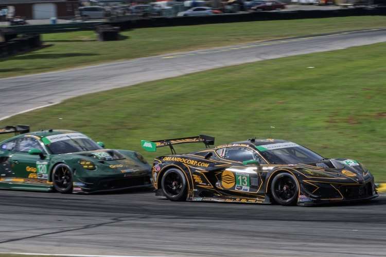 The #13 AWA Corvette Z06 GT3.R in its black and gold livery leads the green Wright Motorsports Porsche at the 2025 IMSA race at VIR.
