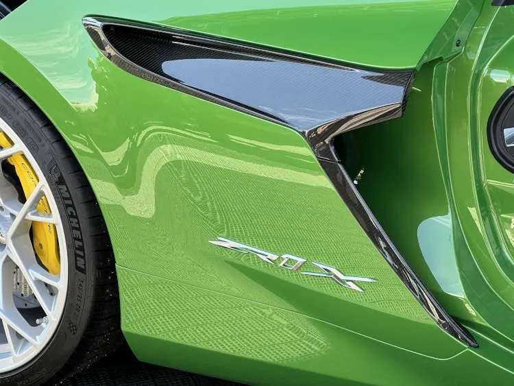 Close-up of the bright green C8 Corvette ZR1X rear quarter panel, featuring the functional carbon fiber side air intake and the chrome ZR1X badge.