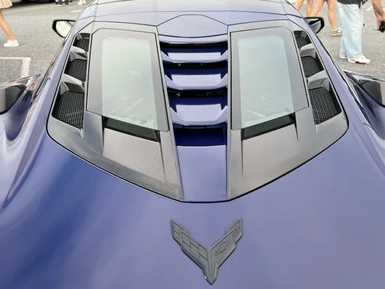 Close-up top view of a blue 2025 Chevrolet Corvette ZR1 featuring the functional split rear window design with carbon fiber vents and Corvette emblem.