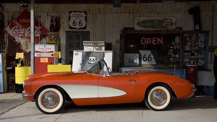 Red and white classic Corvette at filling station.