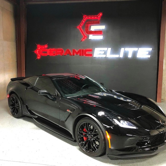 Seventh generation black Corvette Z06 coupe with logo in background