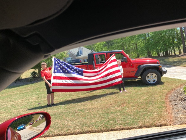 Young people hold in the United States of America flag during the First Responders parade in Pendergrass, Georgia