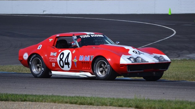 Red C3 Corvette with white side pipes racing during a SVRA event