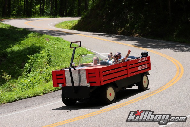 Red wagon modified convertible truck on twisty road
