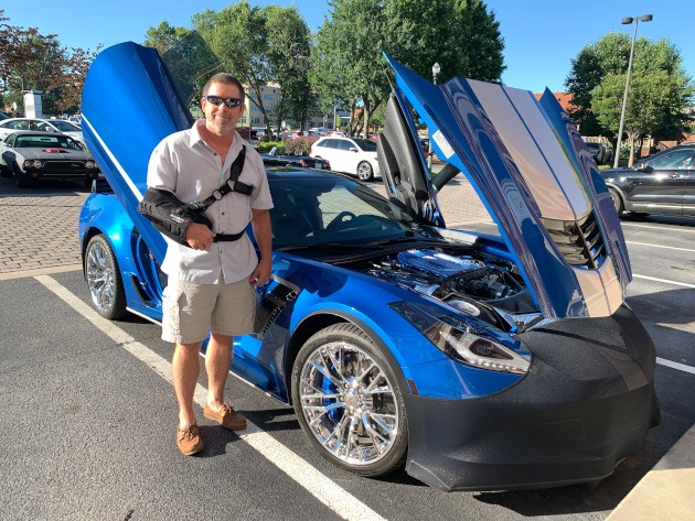 Owner standing beside Elhart Blue seventh-generation Corvette
