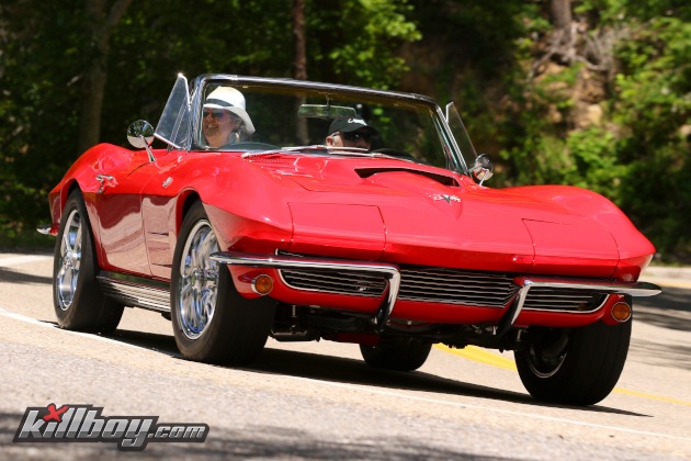 Second-generation red Corvette driving on a twisty road