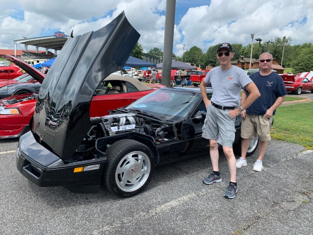 Fourth-generation black Corvette with two men