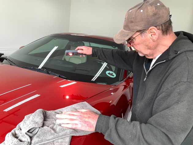 Al Bathurst, owner of Shiny Fenders inspecting paint on a Corvette coupe
