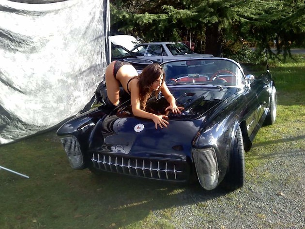 Model posing on hood of 1957 custom Corvette