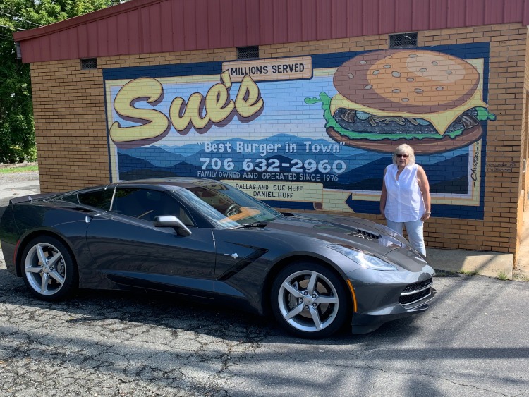 Seventh-generation Shadow Gray Corvette jparked by Sue's burger mural