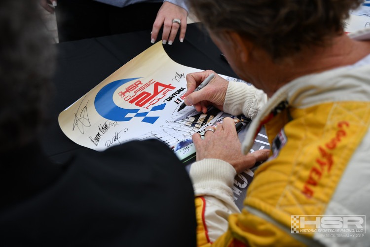 A race car drivers signing a HSR racing poster