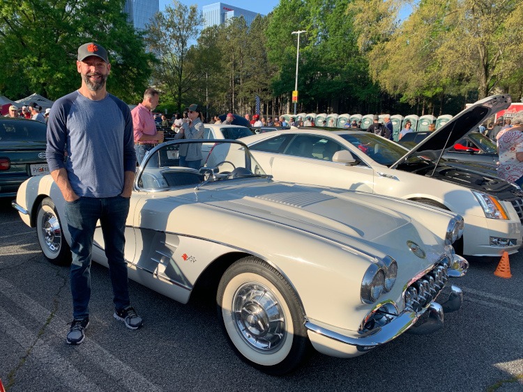 First-generation Corvette roadster with owner standing beside it
