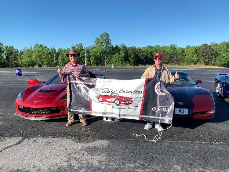 Two members hold banner for the Crusin Corvettes of Tallahasse clube
