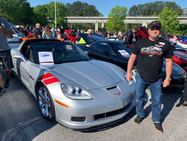 Sixth-generation silver Corvette with owner standing beside it
