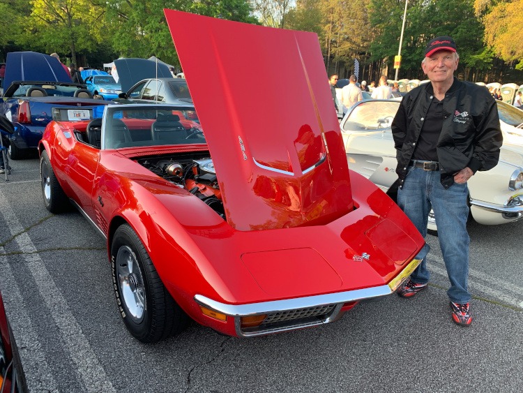 Third-generation Corvette convertible with the owner standing beside it