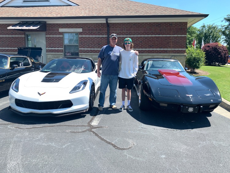 Father and son with their Corvettes at a car show