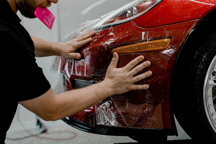 Wrapping XPEL Ultimate Plus to the nose of a red Corvette