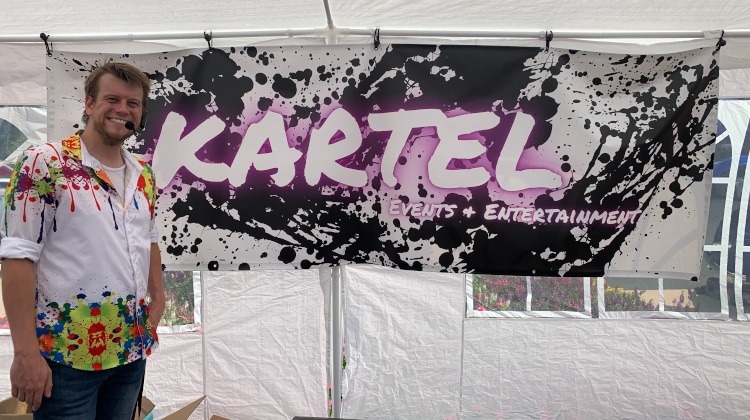 The owner of Kartel events and entertainment beside sign