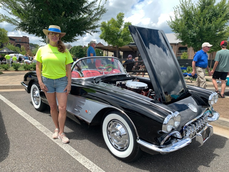 Car Show judge standing by a black first-generation Corvette