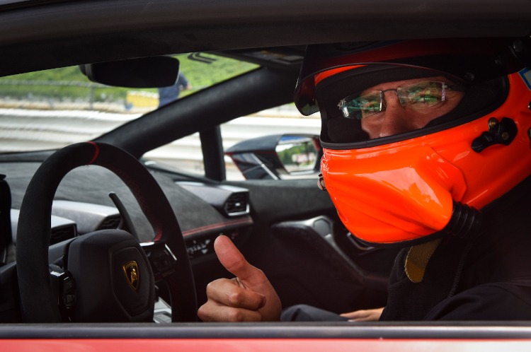 Driver wearing an orange helmet in a car