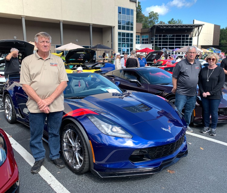 Two corvette owners standing by their Corvettes