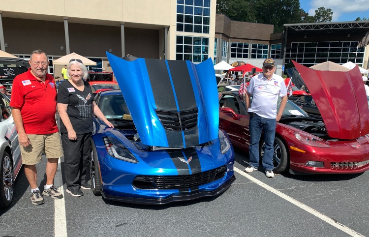 Two Corvette owners standing beside their Corvettes