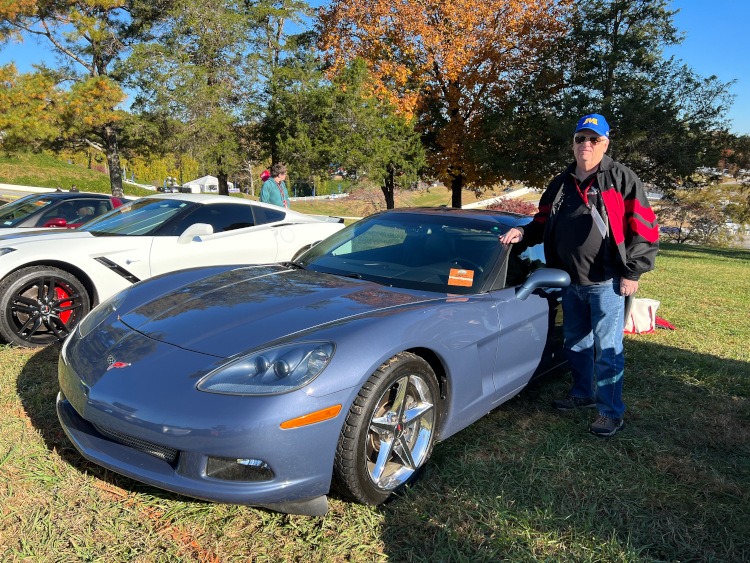 Man standing beside a 2013 base model Corvette