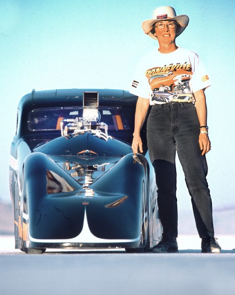 Woman standing beside a Bonneville Salt Flat speed car