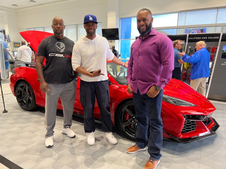 Three men standing beside the new 2023 Z06 Corvette