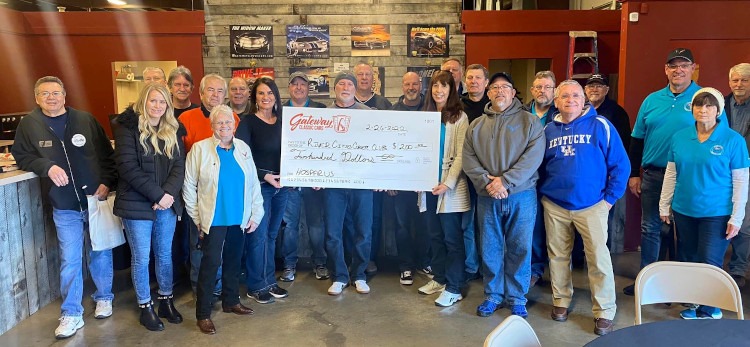 Club members holding a large check from Gateway Classic Cars