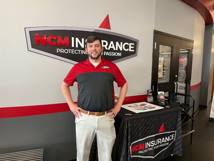 Insurance agent in front of the NCM Insurance logo
