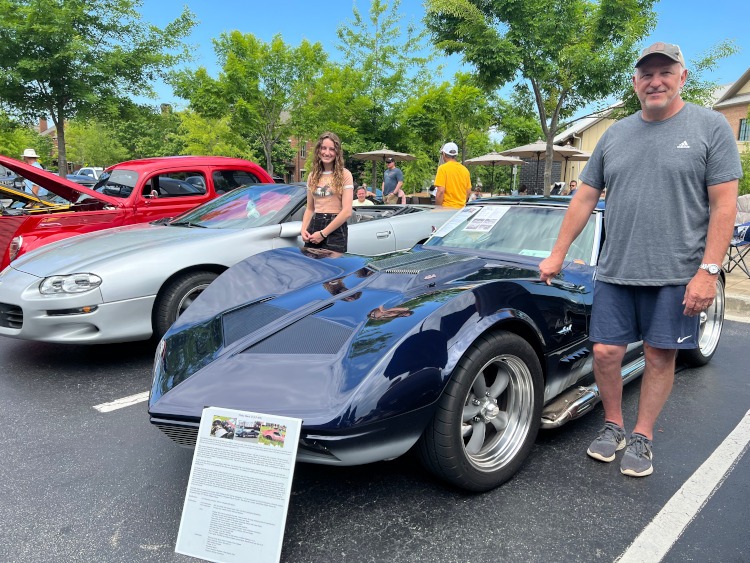 A silver Camaro convertible and a blue custom Corvette