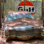 Vintage blue Cadillac with a Gulf oil sign