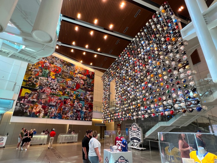 The wall of murals and helmets at the College Football Hall of Fame.