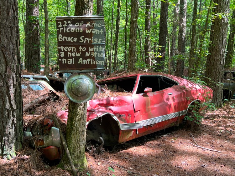 Wrecked two door car in the woods