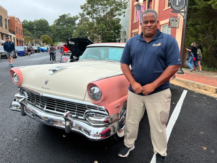 Man standing beside a classic automobile
