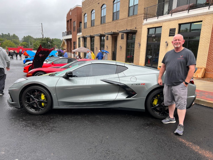 Man standing beside a 2022 grey C8.R edition Corvette coupe
