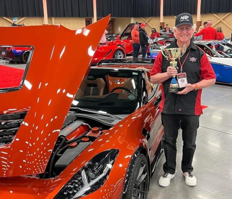 Man holding a trophy at a car show