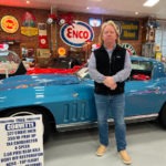 Man standing beside a blue 1966 Corvette coupe.