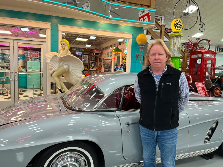 Greg Wyatt standing beside a vintage corvette