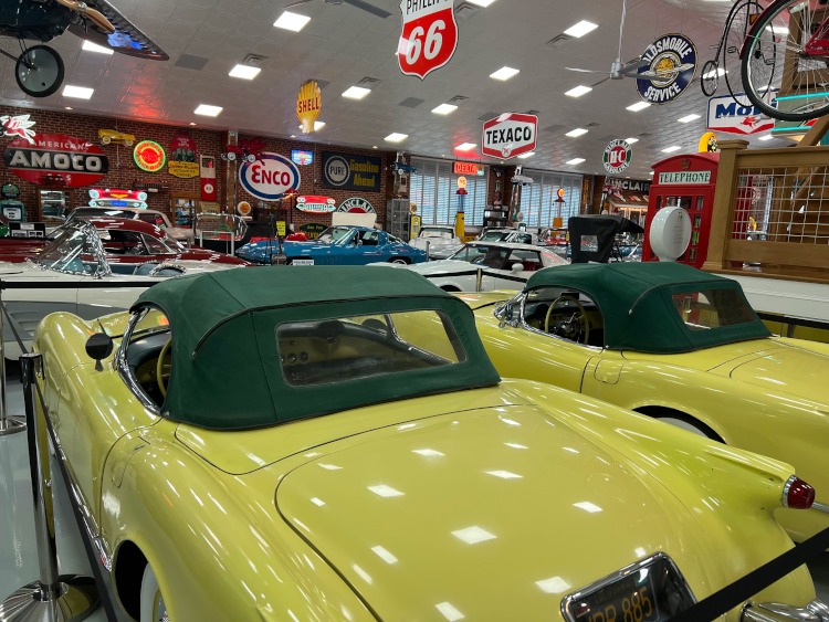 Two yellow C1 generation Corvettes in a museum.