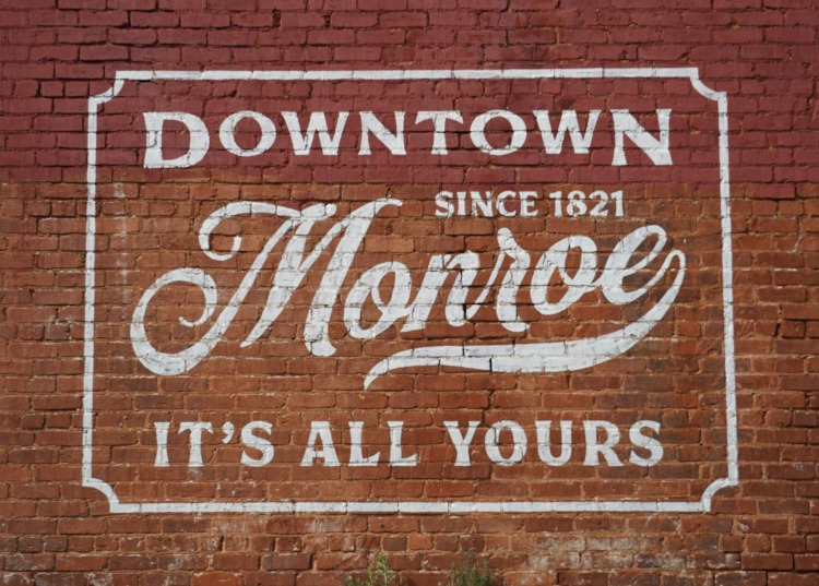 Downtown Monroe sign on a brick wall.