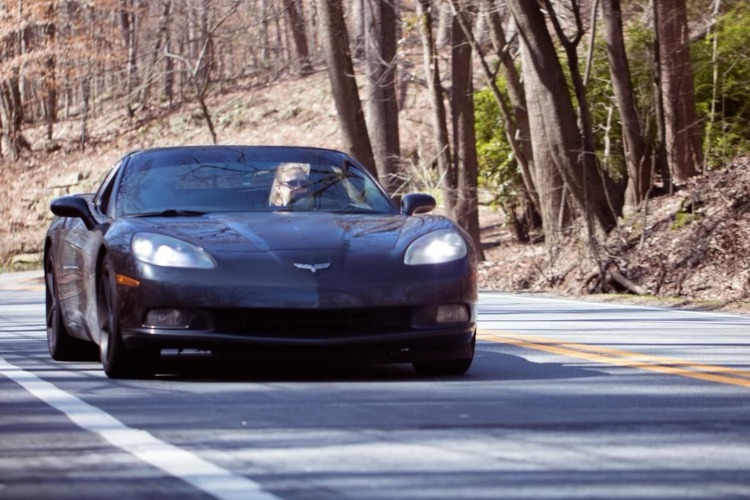 Black Corvette coupe on a twisty road in the Georgia mountains.