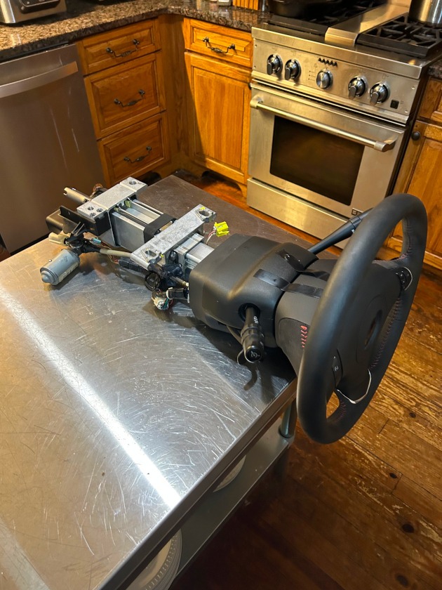 A steering assemly with steering wheel on a kitchen table.