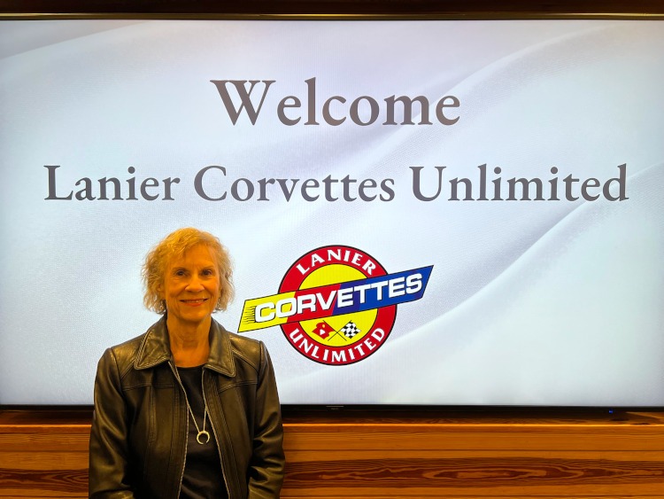 Lanier Corvettes Unlimited member standing in front of LCU sign
