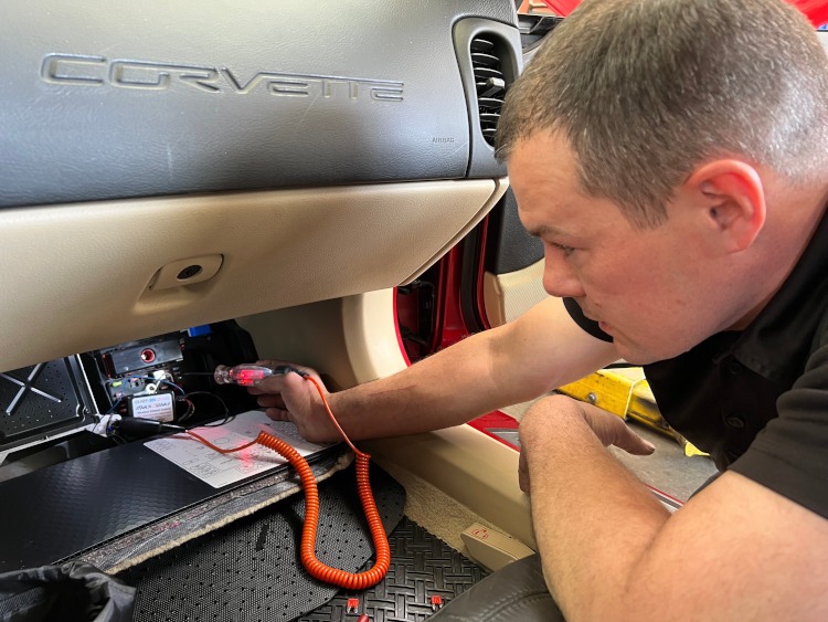Technician checks the fuse on a Corvette
